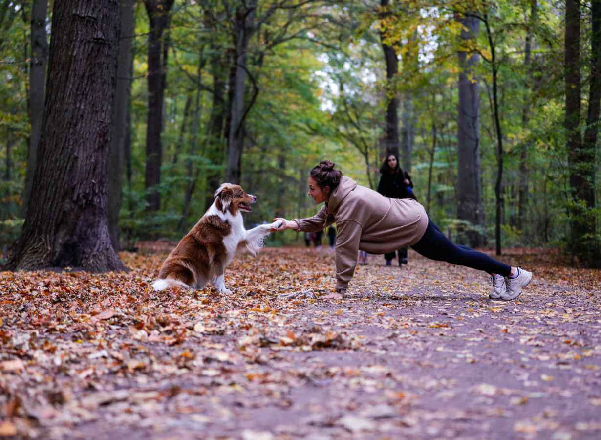 Halterin macht Sport mit ihrem Hund im Wald
